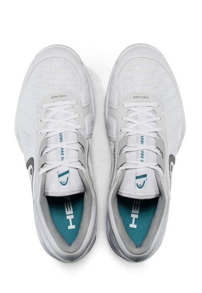 Viewed from above, this pair of HEAD Sprint Pro 3.0 Men's Grass Court Tennis Shoes showcases a white design with grey accents. Featuring a teal insole emblazoned with the HEAD logo, these shoes provide added stability for an optimal fit with their Delta Straps. The tongues display text that includes the shoe size and model information.