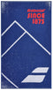 The Babolat Medium Towel - Sodalite Blue, made from 100% cotton, features a vibrant blue background with white geometric mountain shapes and a speckled design. Bold red text at the top proudly displays "Babolat SINCE 1875," while the iconic logo of two diagonal lines is elegantly placed at the bottom, making it an ideal court towel.