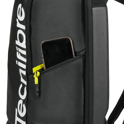 A close-up of the black Tecnifibre Reform Tennis Backpack with a side zipper pocket, partially open to show a smartphone inside. The white Tecnifibre logo appears on this stylish and functional tennis racket bag.