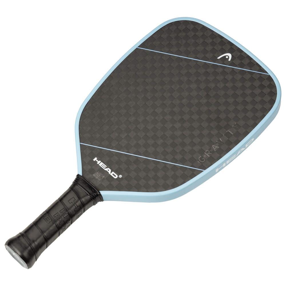The HEAD Gravity Tour 2025 Pickleball Paddle in Carbon Black/Blue features a textured 12K carbon face, cushioned black grip, blue edge, and “HEAD” branding near the handle.