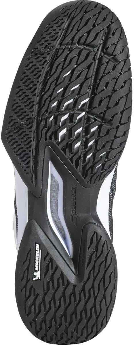 The image displays the black rubber outsole of the Babolat Jet Tere 2 All Court Men's Tennis Shoe, featuring a patterned tread with crisscross grooves and textured areas designed to offer superior grip and support on all court surfaces.