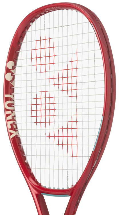 A close-up of the Yonex 08 VCORE 100L 2026 Tennis Racket in Ruby Red shows white strings with a red logo pattern and "YONEX" visible on the frame, designed for enhanced spin.