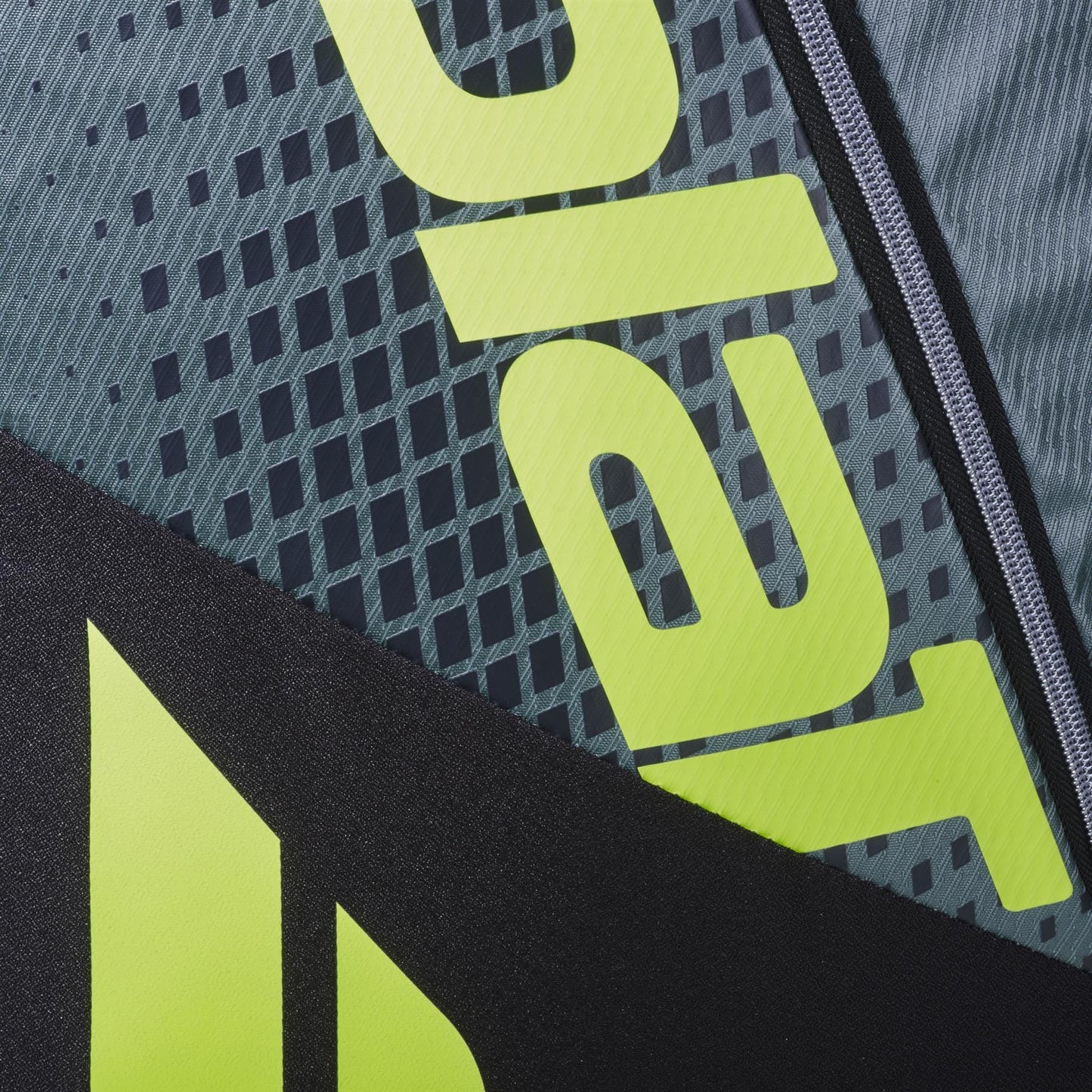 Close-up of the Babolat RH6 Pure Aero 6 Racket Tennis Bag in grey/yellow, showing its textured surface, bold partial yellow text, black diagonal stripe, geometric background pattern, zipper detail, and distinctive Babolat design elements.