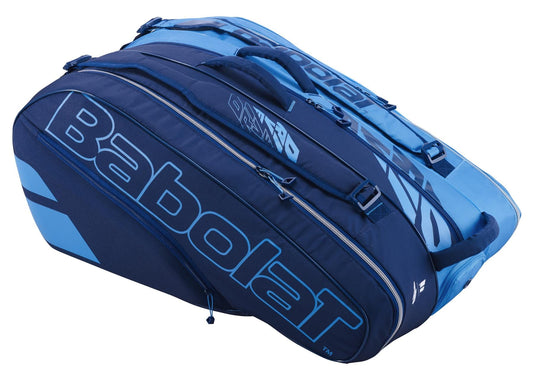 The Babolat RH12 Pure Drive 12 Racket Tennis Bag in blue is a stylish and practical choice for any tennis enthusiast, featuring the iconic Babolat branding prominently in large letters. It offers multiple compartments, including an insulated section, all accessible via convenient zippers.