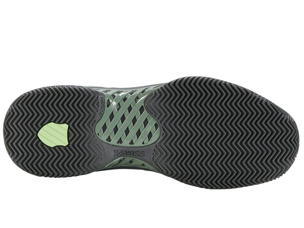 The image displays the sole of a K-Swiss Express Light 3 HB men's tennis shoe in Sea Spray, Urban Chic, and Soft Neon Green. It has a zigzag tread pattern for improved grip on clay court surfaces, with a highlighted support area and the brand name "K-Swiss" prominently featured near the center to enhance on-court performance.