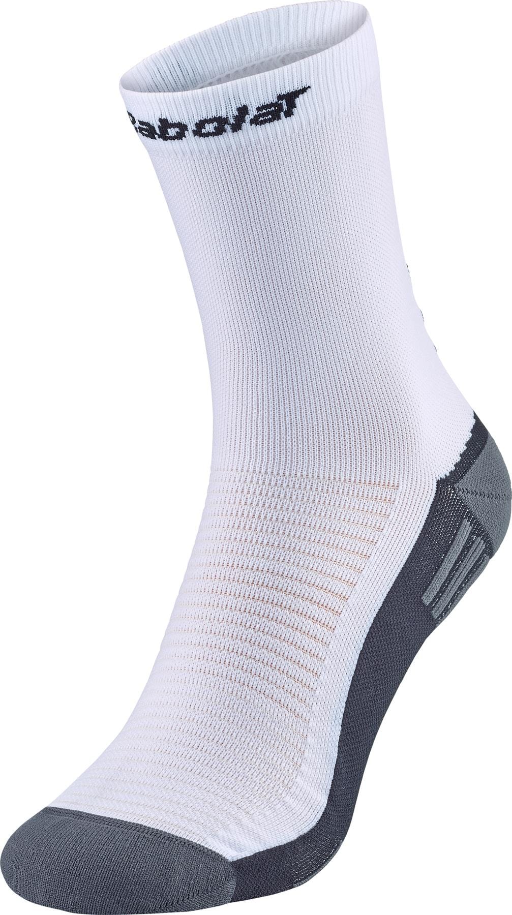 The Babolat Mid-Calf Tennis Sock in white features gray accents on the heel and toe, a ribbed texture, and "Babolat" in black near the top.