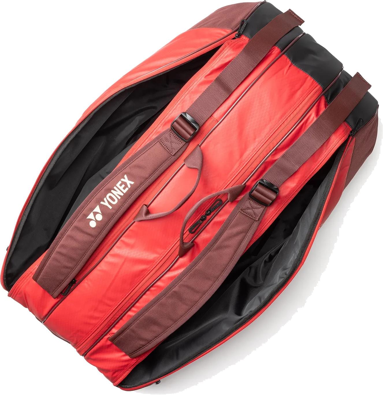 The Yonex 42529EX Team 9 Racket Tennis Bag in Ruby Red features brown straps, a spacious dual-compartment interior when unzipped, and the white Yonex logo printed on one side.