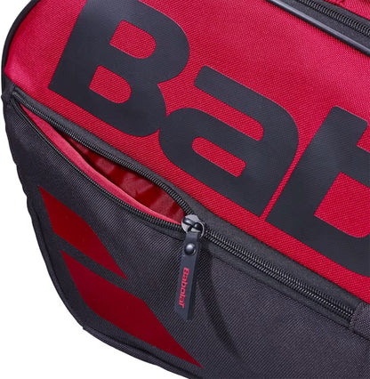 Close-up of the Babolat Court L 9 Racket Tennis Bag in burgundy and black, featuring a prominent Babolat logo, made from recycled polyester with zippered compartments and a branded zipper pull.