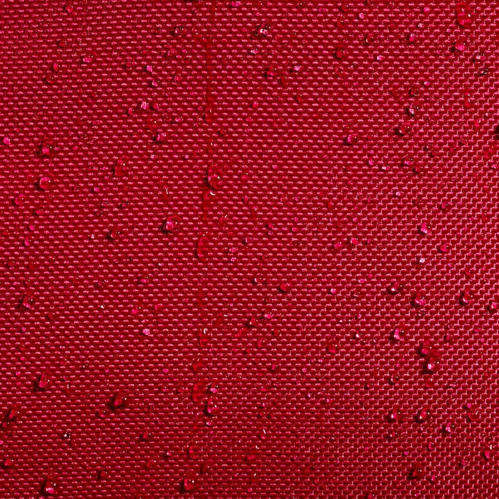 Close-up of the burgundy woven fabric of the Babolat Court L 9 Racket Tennis Bag, showing textured recycled polyester with small water droplets beading on the surface.