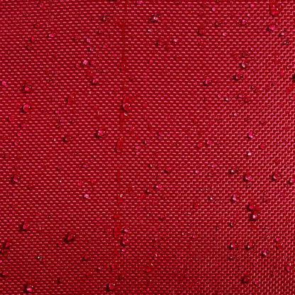 Close-up of the burgundy woven fabric of the Babolat Court L 9 Racket Tennis Bag, showing textured recycled polyester with small water droplets beading on the surface.