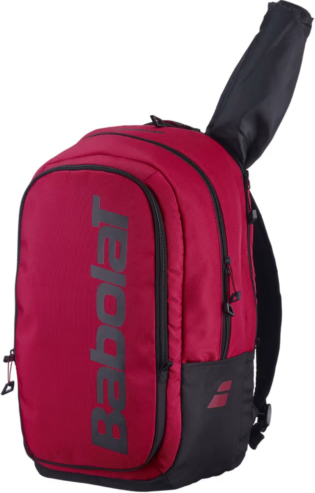 The Babolat Court Hero Tennis Backpack in Burgundy and Black, crafted from recycled polyester with black zippers, showcases a racquet partially stored in the back compartment. A bold vertical Babolat logo is printed on the front pocket, combining style and eco-friendliness in this standout tennis bag.