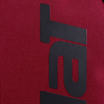 A close-up of the black Babolat logo, featuring the letter "T" and a stylized "R," printed on the textured burgundy fabric of the Babolat Court Hero Tennis Backpack—crafted from recycled polyester for a premium look and feel.