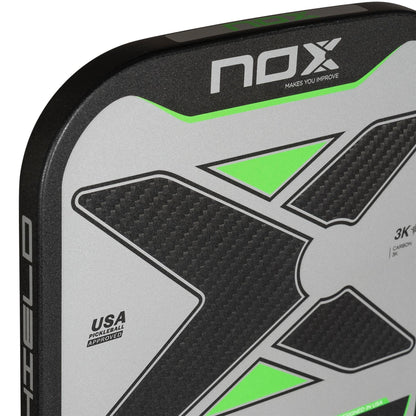 Close-up of the NOX NOV Pro Shield Pickleball Paddle - Black / Green, showcasing a textured carbon fiber X design, neon green accents, spin technology, and a "USA Pickleball Approved" label.