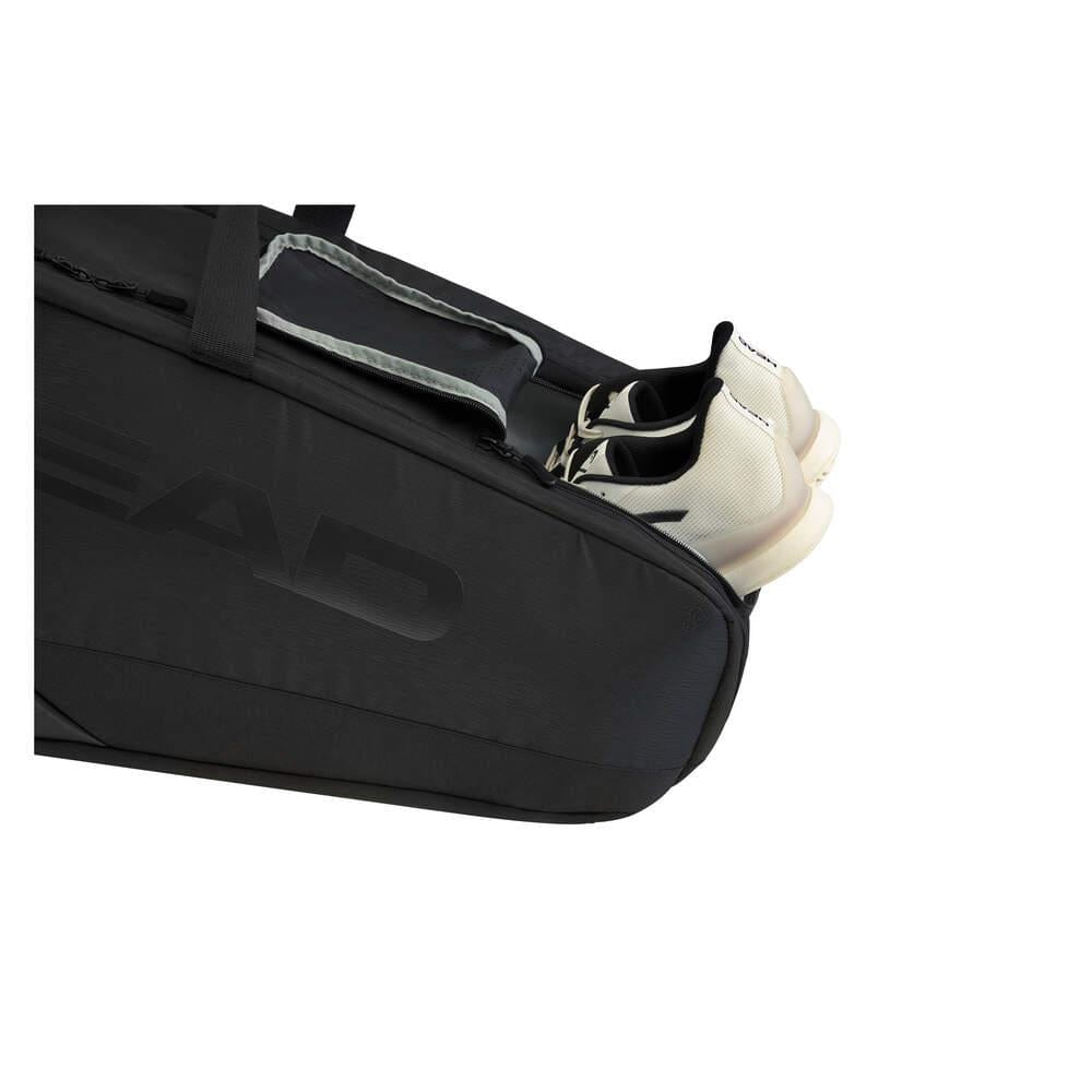The HEAD Pro X Legend 9 Tennis Racket Bag L - Black, endorsed by Novak Djokovic, showcases a sleek design with an open compartment revealing a pair of white shoes partially inside. It features a visible zipper and strap and is equipped with CCT+ climate control technology to protect your gear.