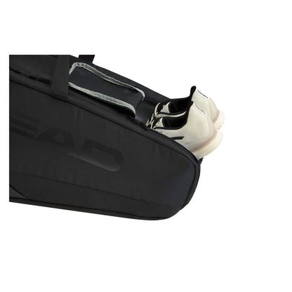 The HEAD Pro X Legend 9 Tennis Racket Bag L - Black, endorsed by Novak Djokovic, showcases a sleek design with an open compartment revealing a pair of white shoes partially inside. It features a visible zipper and strap and is equipped with CCT+ climate control technology to protect your gear.