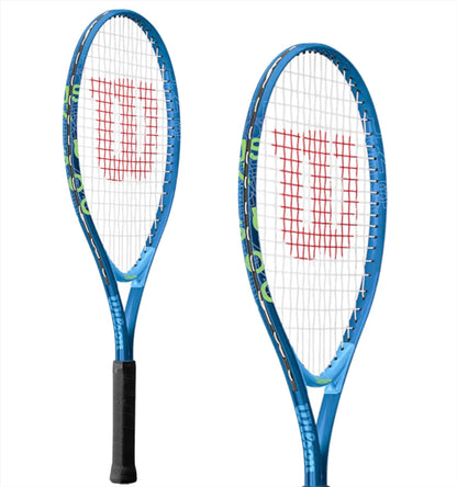 Photographed against a white background are two Wilson US Open 25 Junior Tennis Rackets in blue and white, featuring red "W" logos on the strings. The rackets have black handles and frames with green accents, designed with AirLite frame construction for improved playability.