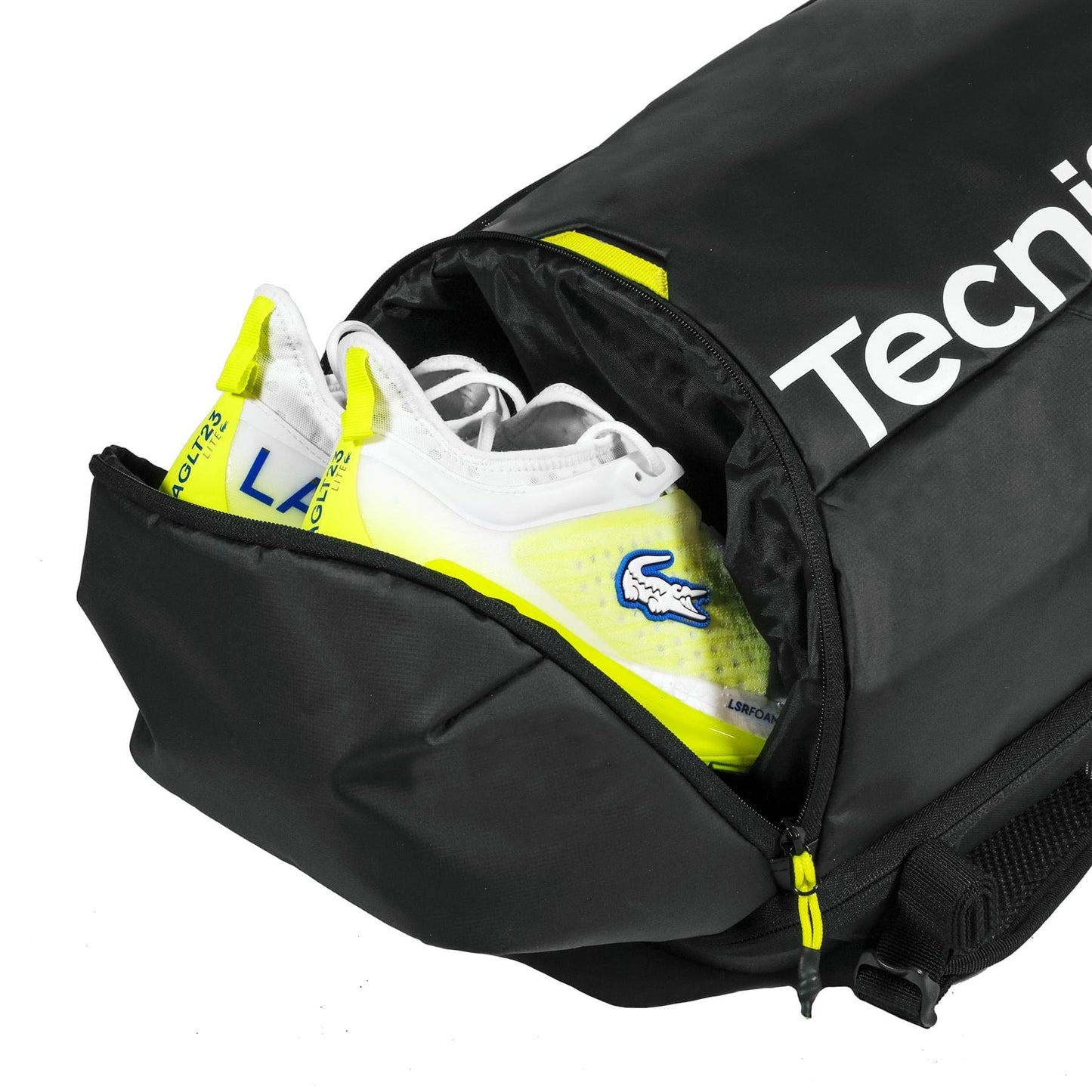 A pair of white and yellow sports shoes are partially visible inside a black Tecnifibre Reform Tennis Backpack, with one compartment unzipped to reveal the shoes.