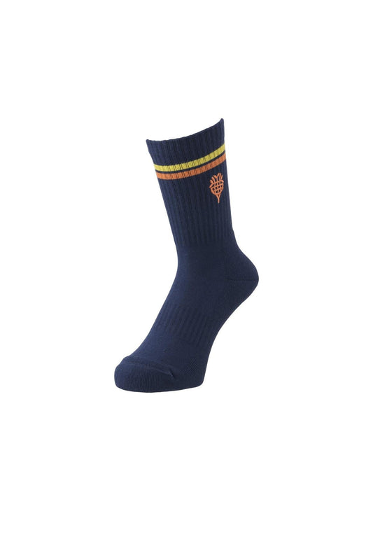 This single sock from the Yonex Nature Series, Midnight Navy edition, is crafted from recycled polyester. It showcases two horizontal stripes in yellow and orange at the top, along with a small orange tree emblem below. The design of the Yonex Nature Series 19215 Tennis Socks is elegantly highlighted against a plain white background.