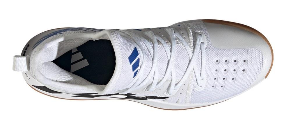 Top view of the ADIDAS Stabil Next Gen Primeblue men's indoor shoes, featuring a cloud white design with core black accents and a lace-up closure. Perforations enhance ventilation, while the light brown sole provides energy return. The insole prominently displays the adidas logo.