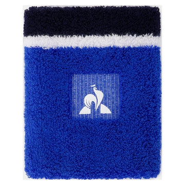Introducing the Le Coq Sportif Tennis Sweatband in Lapis Blue—this fluffy, rectangular accessory showcases a striking blue and white design. It prominently features Le Coq Sportif's signature stylized bird logo in white set against a vibrant blue backdrop. The top section is adorned with a distinctive white stripe bordered by sleek black stripes.
