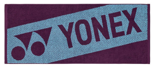 The Yonex AC1113EX Tennis Sports Towel - Bordeaux is a 100% cotton rectangular towel with a Bordeaux background, featuring the Yonex logo and name diagonally—ideal for your sports sessions.