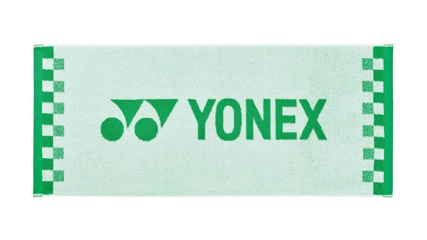 A white Yonex AC1109EX Face Towel featuring a checkered pattern along the edges, crafted from premium cotton. The green Yonex logo and name are prominently displayed at the center, making it an ideal workout towel for sports enthusiasts.