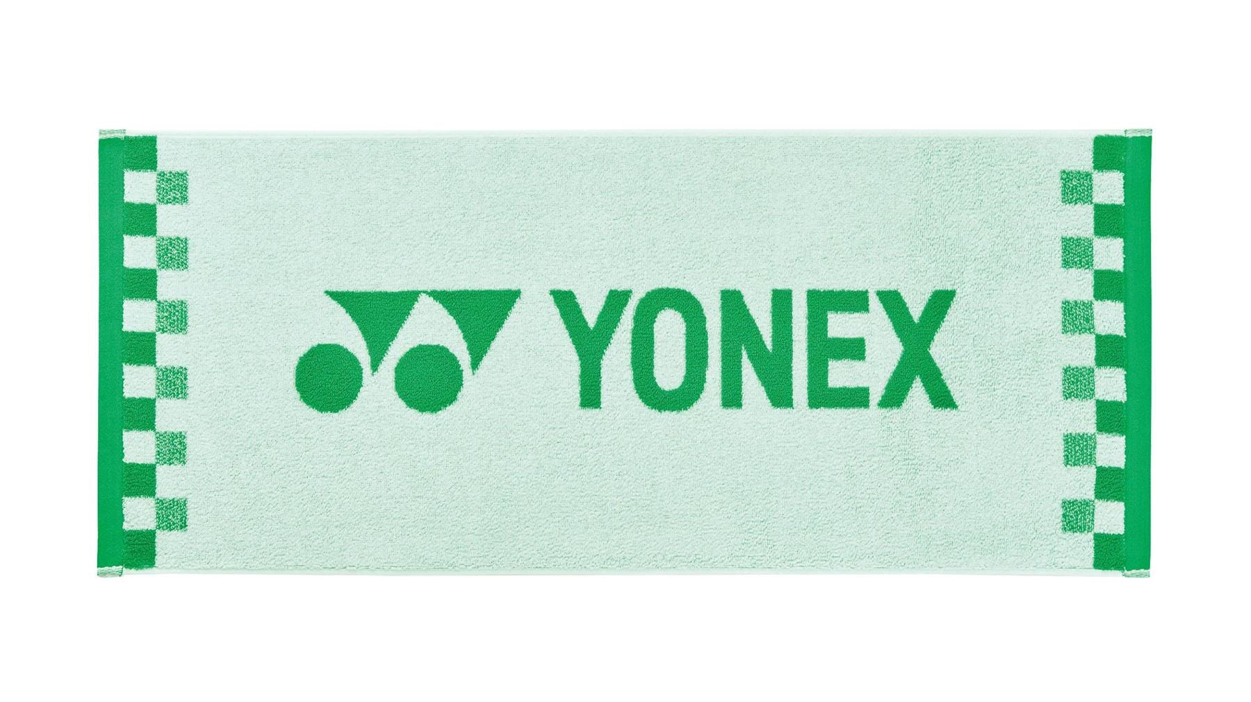 A white Yonex AC1109EX Face Towel featuring a checkered pattern along the edges, crafted from premium cotton. The green Yonex logo and name are prominently displayed at the center, making it an ideal workout towel for sports enthusiasts.