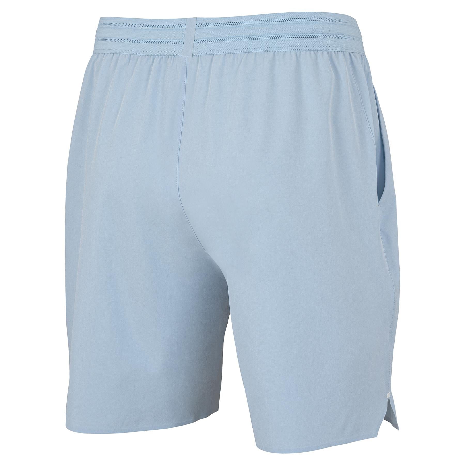 Tecnifibre Team Stretch Men's Tennis Shorts in Glacier Blue, shown from back and side. These minimalist shorts feature an elastic waistband, side pockets, and a stretch design with no visible logos or patterns.