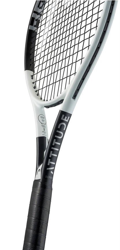 Close-up of the HEAD MX Attitude SUPRM Tennis Racket by HEAD, a lightweight beginner racket with "ATTITUDE" on the throat, a wrapped black grip, and taut strings shown against a white background.