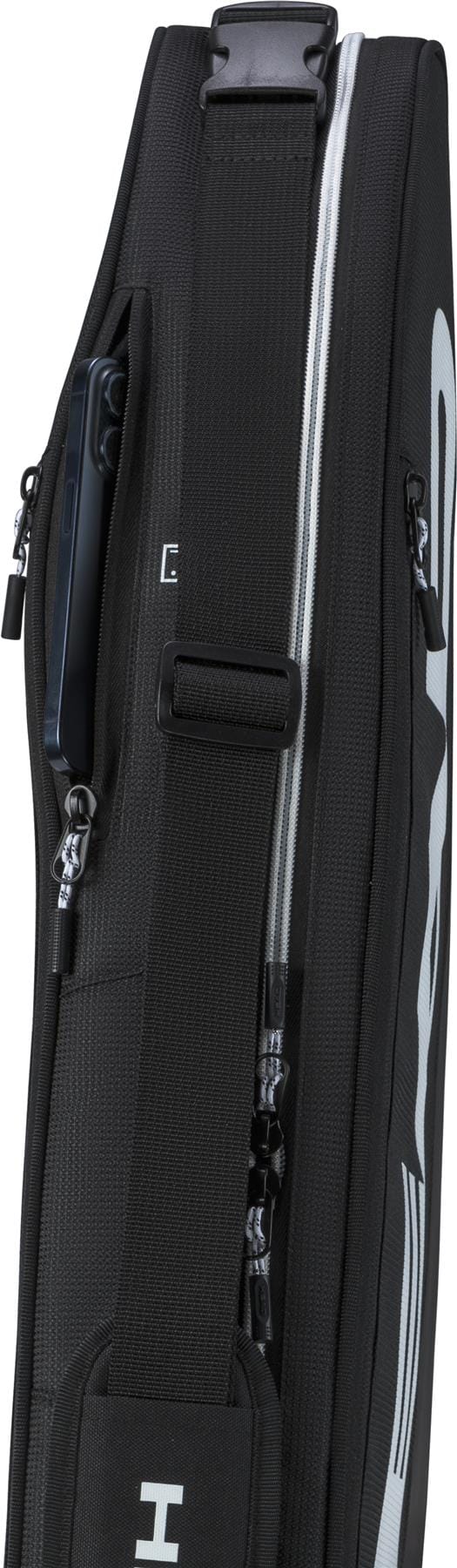 Close-up side view of the compact HEAD Tour 3 Racket Tennis Bag S by HEAD in black, featuring white accents, zippers, a strap, and a phone partially visible in an exterior pocket.