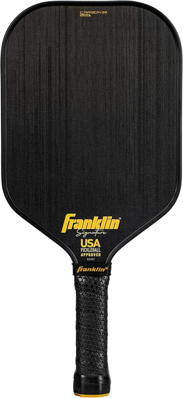 The Franklin Carbon STK 17mm Pickleball Paddle features a black textured surface, yellow "Franklin" logo, "USA Pickleball Approved" text above the black grip, and is officially USAPA approved.