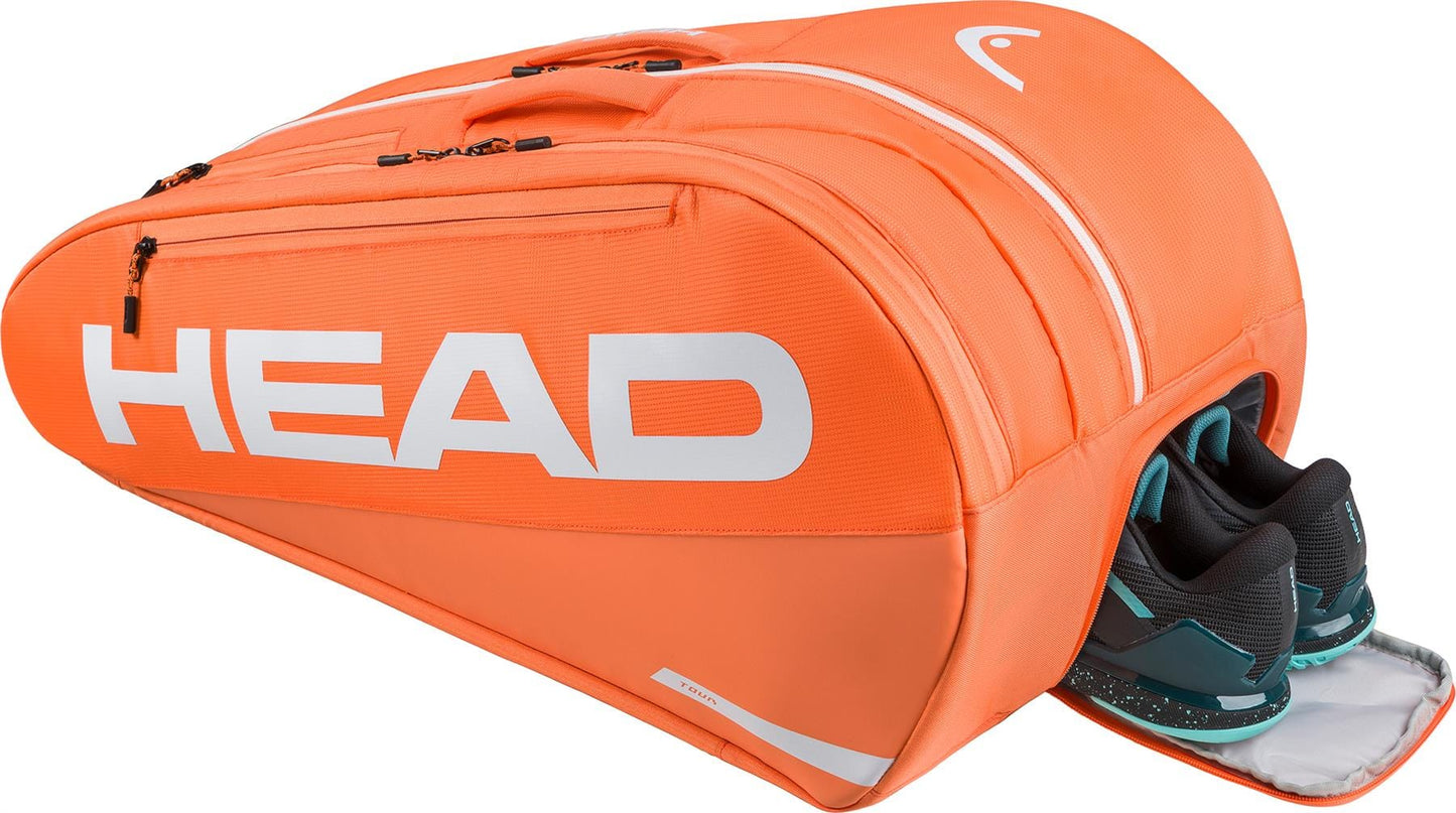 The HEAD Tour 12 Racket Tennis Bag XL in orange features bold white branding, multiple zip compartments, a ventilated shoe section for black and teal athletic shoes, and climate control technology.