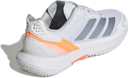 The adidas Defiant Speed 2 Women’s Tennis Shoes in Cloud White/Halo Blue/Beam Orange feature gray stripes, orange accents, “DEFIANT SPEED” on the side, a textured sole, perforated heel detail, and a lightweight design.