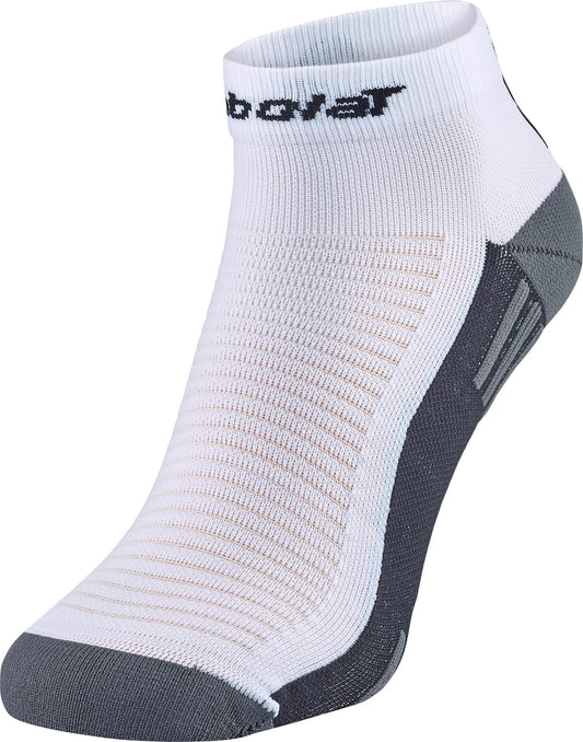 The Babolat Quarter Tennis Socks in white/black feature a ribbed texture, reinforced heel and toe, and 3D pads for comfort. Designed for athletic performance, the socks have black branding near the cuff and are shown upright on a white background.