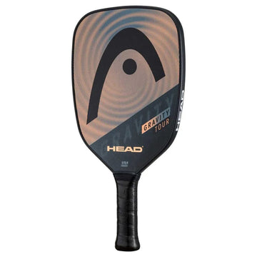 The HEAD Gravity Tour 2023 Pickleball Paddle by HEAD features SpinOn technology, a black handle, rounded rectangular face, and a black, gold, and tan design with the HEAD logo and "Gravity Tour" text on the face.