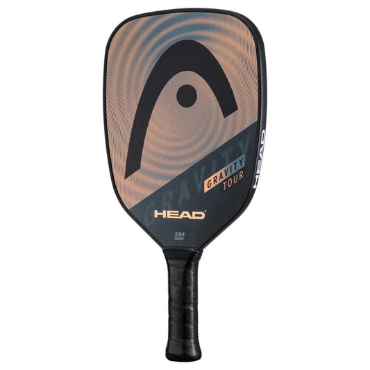 The HEAD Gravity Tour 2023 Pickleball Paddle in Black/Bronze features a black handle, rounded rectangular face with SpinOn technology, large black logo, and gradient beige graphics. The HEAD brand and model name appear on the Hybrid Hitting Surface.