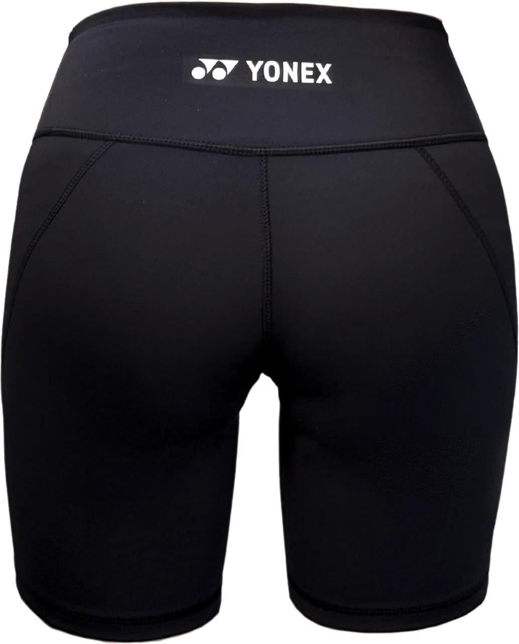 Yonex YTS2024 Womens Core Tennis Shorts in black, shown from the back, feature moisture-wicking fabric, flat seams, and a white Yonex logo on the waistband—ideal for comfort and performance on the court.