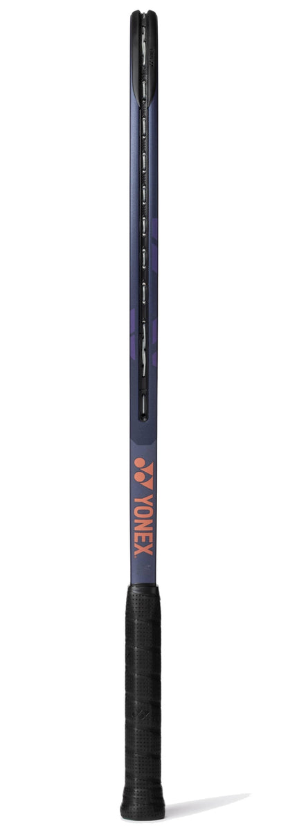 The Yonex Percept 100 Tennis Racket - Midnight Navy is shown vertically from the side, featuring a black grip, dark midnight navy frame with purple accents, and an orange "YONEX" logo—ideal for intermediate players.