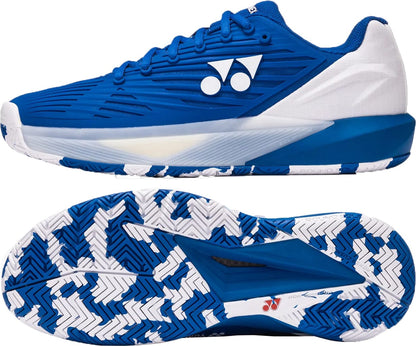 The Yonex Power Cushion Eclipsion 5 Mens Tennis Shoes in blue and white, shown from the side and bottom, feature a blue and white zigzag sole pattern and Yonex’s geometric logo with two circles and a triangle on the side.
