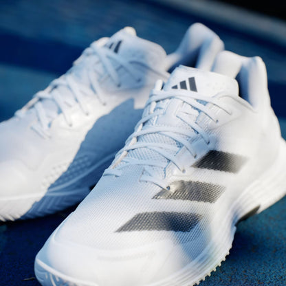 A pair of adidas Defiant Speed 2 Men's Tennis Shoes in Cloud White, Core Black, and Grey are side by side on a blue surface, highlighting their lightweight design and sporty look.