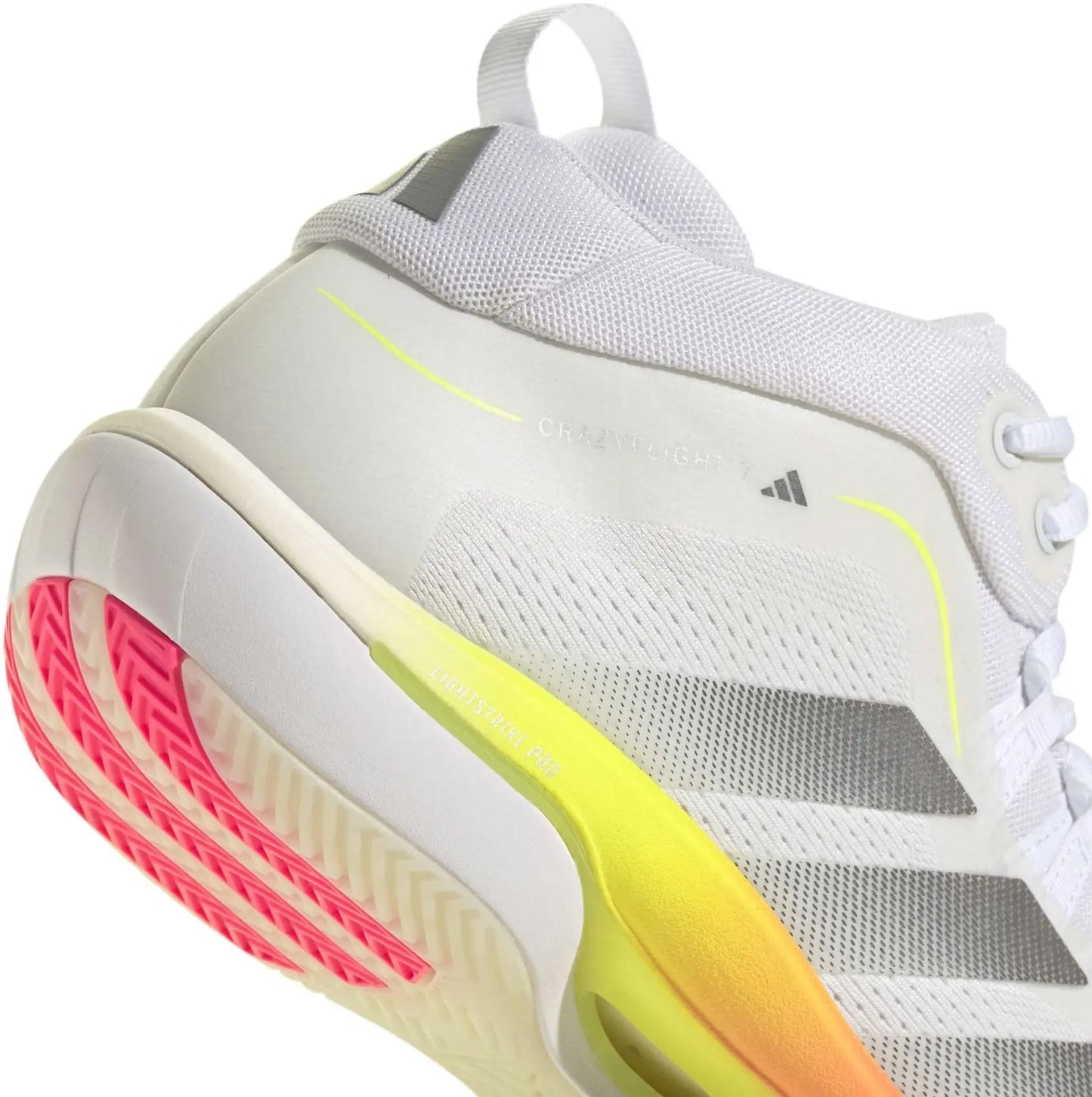 A close-up of the adidas Crazyflight 7 Men’s Indoor Tennis Shoes in Cloud White/Iron Metallic, featuring gray stripes, neon yellow accents, a pink-tinted outsole, and BOOST midsole cushioning. The shoe's heel and side design are highlighted.