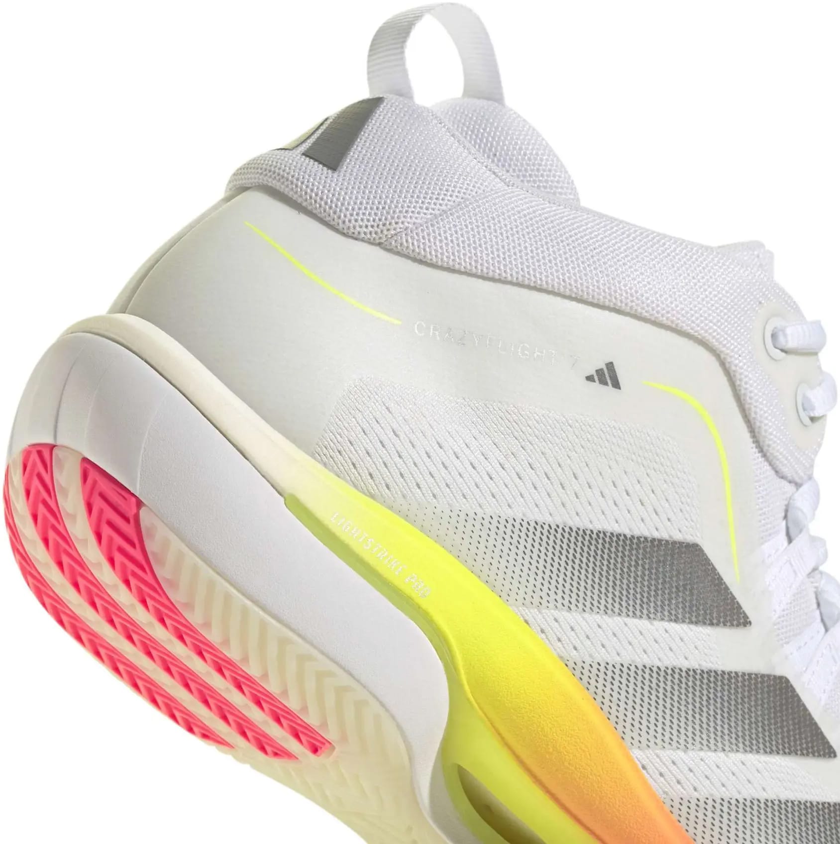 A close-up of the adidas Crazyflight 7 Men’s Indoor Tennis Shoes in Cloud White/Iron Metallic, featuring gray stripes, neon yellow accents, a pink-tinted outsole, and BOOST midsole cushioning. The shoe's heel and side design are highlighted.
