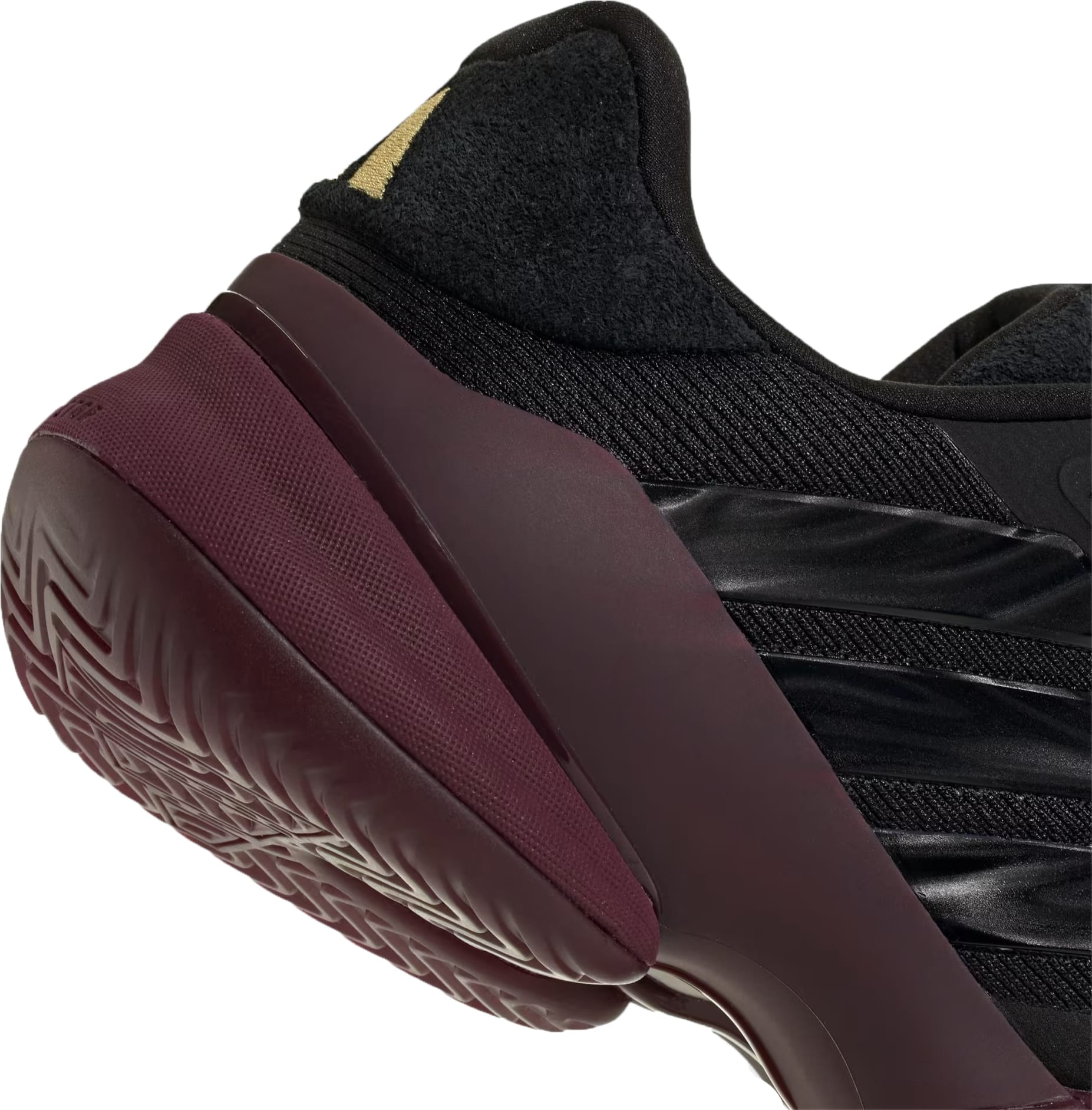 Close-up of the heel and side of the adidas Barricade 14 Men’s Tennis Shoes in Core Black, featuring a maroon sole and a gold accent on the upper heel. Inspired by iconic design elements for baseline players, these shoes have a textured outsole pattern that ensures optimal grip.