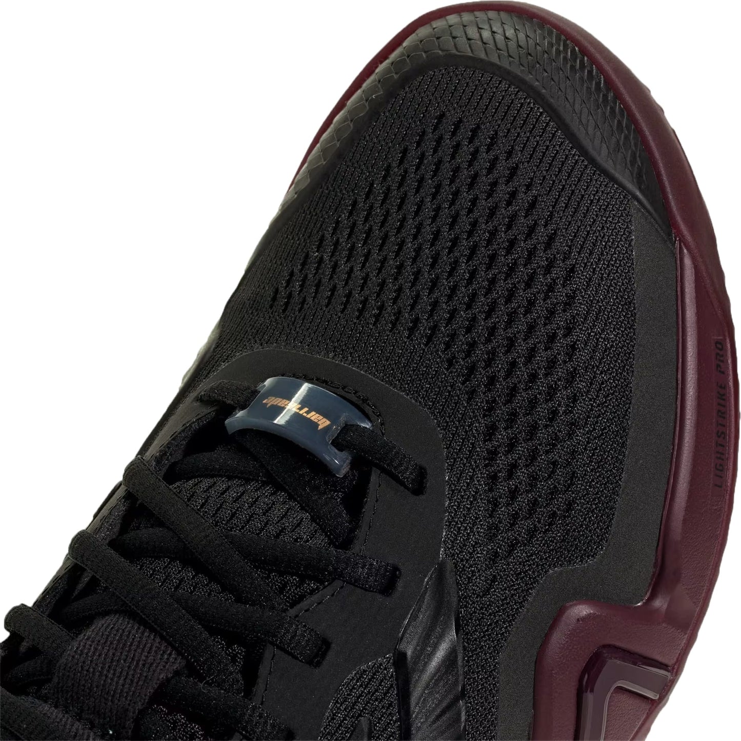 A close-up of the adidas Barricade 14 Men’s Tennis Shoes in Core Black with Maroon accents and mesh detailing, showcasing the laces, toe box, and part of the sole—ideal for baseline players seeking performance-focused footwear.