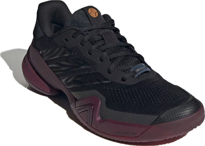 The adidas Barricade 14 Men’s Tennis Shoes in Core Black/Core Black/Maroon feature maroon accents, a breathable mesh upper, classic lace closure, signature adidas stripes on the side, and a textured sole. Expertly engineered for performance sports, these shoes are a trusted choice among baseline players seeking reliable men’s tennis footwear.