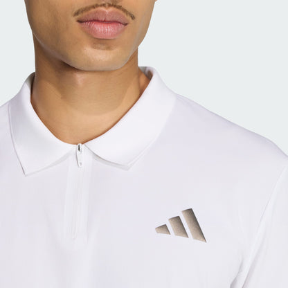 A close-up shows a person wearing the adidas Climacool Mens Tennis Polo Shirt in white, featuring a short zipper and adidas logo on the chest. The shot highlights the shirt’s stylish, breathable tennis design.