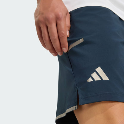 Close-up of a hand pulling the side pocket zipper on adidas Climacool Mens Tennis Shorts in Aurora Ink, featuring a small hem slit—combining performance and comfort in breathable tennis gear from adidas.