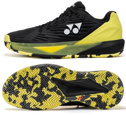 The Yonex Power Cushion Eclipsion 5 Men’s Tennis Shoes in Black/Yellow are displayed from the side and bottom, highlighting the Yonex logo and a patterned sole with zigzag traction for superior stability and performance on court.