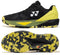 The Yonex Power Cushion Eclipsion 5 Men’s Tennis Shoes in Black/Yellow are displayed from the side and bottom, highlighting the Yonex logo and a patterned sole with zigzag traction for superior stability and performance on court.