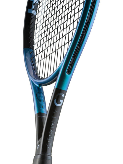 Close-up of the HEAD IG Gravity XCEED Tennis Racket by HEAD, featuring a modern blue and black graphite frame with standout strings, a prominent “G” on the frame, and stylish design details along the shaft.